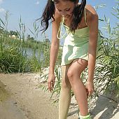 Dark-haired juvenile sweetheart taking off her suit on the wild beach.